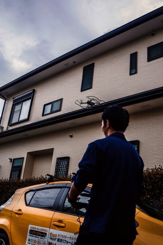 スタッフがドローンで屋根まわりを点検している様子