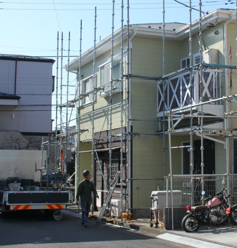 足場を組んで工事中の住宅